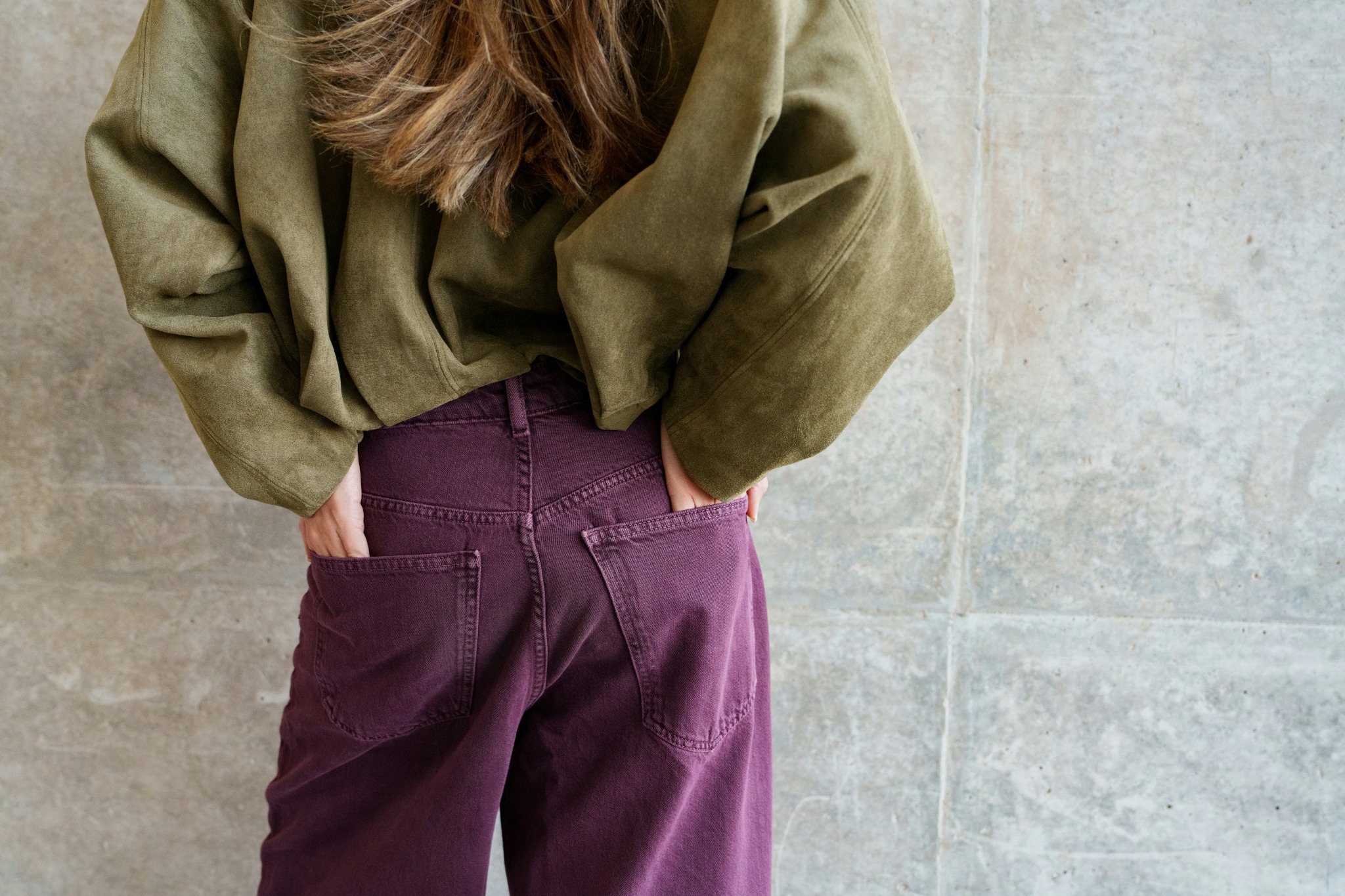 Close-up of purple trousers and an olive-green jacket.